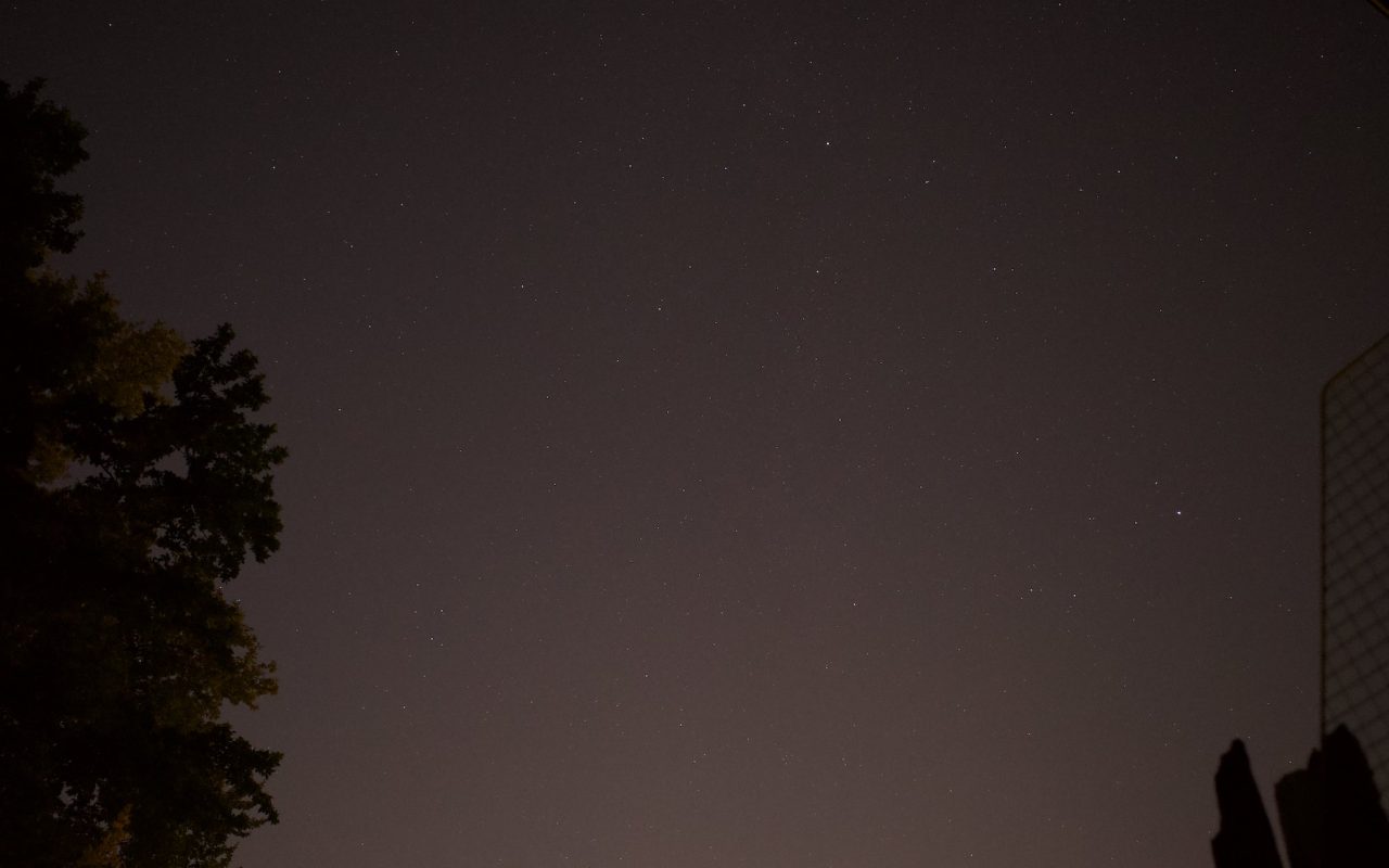 Fig. 1. Light-polluted night sky. Excerpt of my backyard night sky with high light pollution due to street behind the building, cars and street lights. The band of the milky way is very faint. (Bortle scale 7-8)